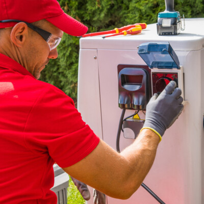 installateur de pompe a chaleur qui branche l'appareil sur le circuit électrique