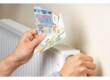 Billets euros à côté d'un radiateur qui chauffe mal